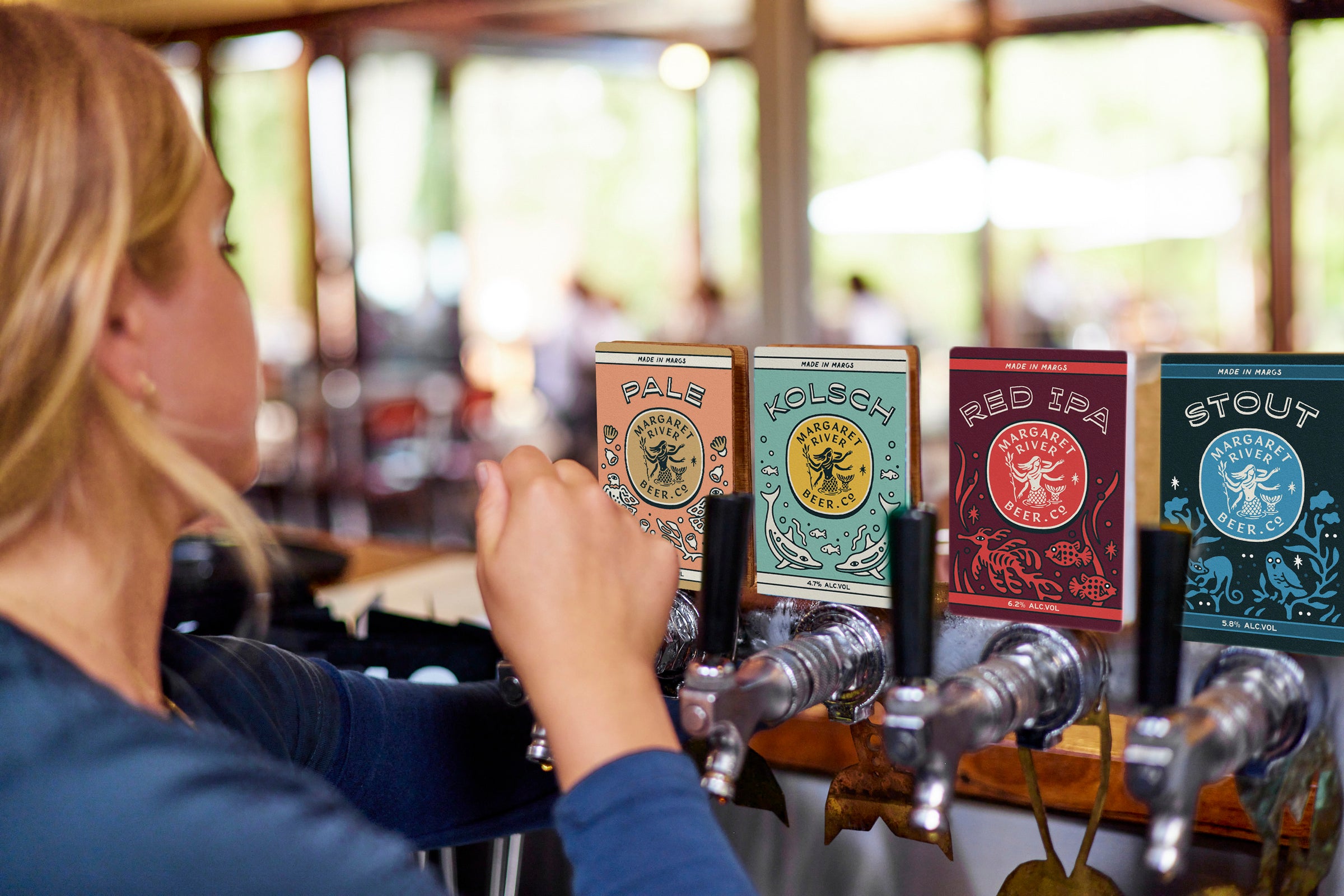 blonde hair female pouring beer from a tap in brewpub